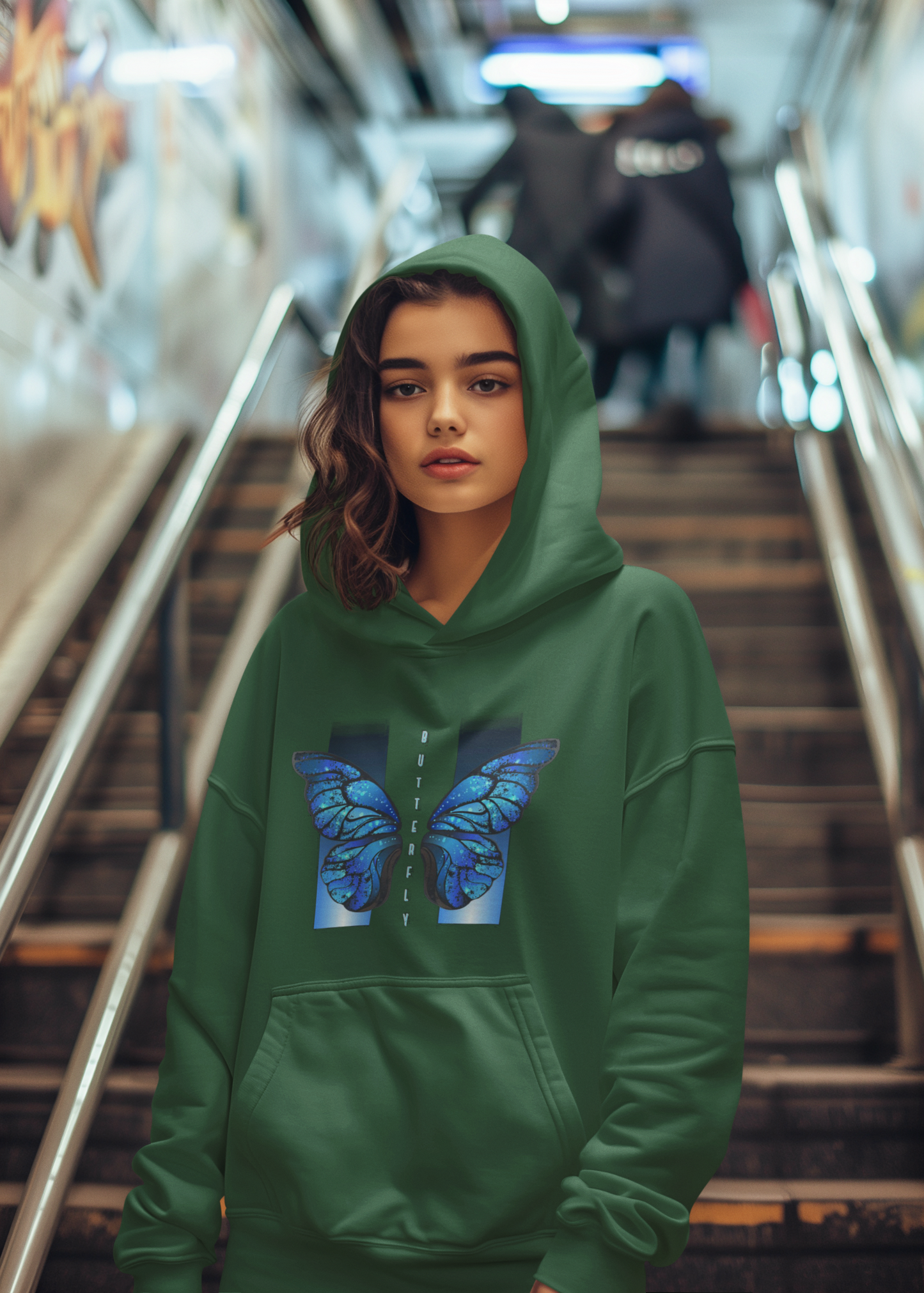 Person wearing a green hoodie with a butterfly design in an urban setting