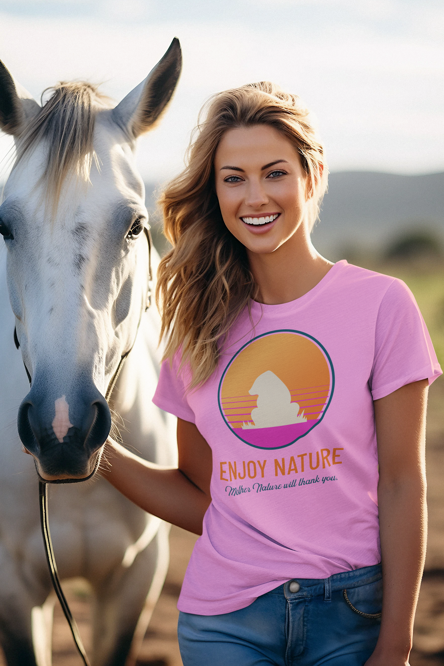 Woman wearing a pink t-shirt with a nature graphic and text, standing next to a horse outdoors.