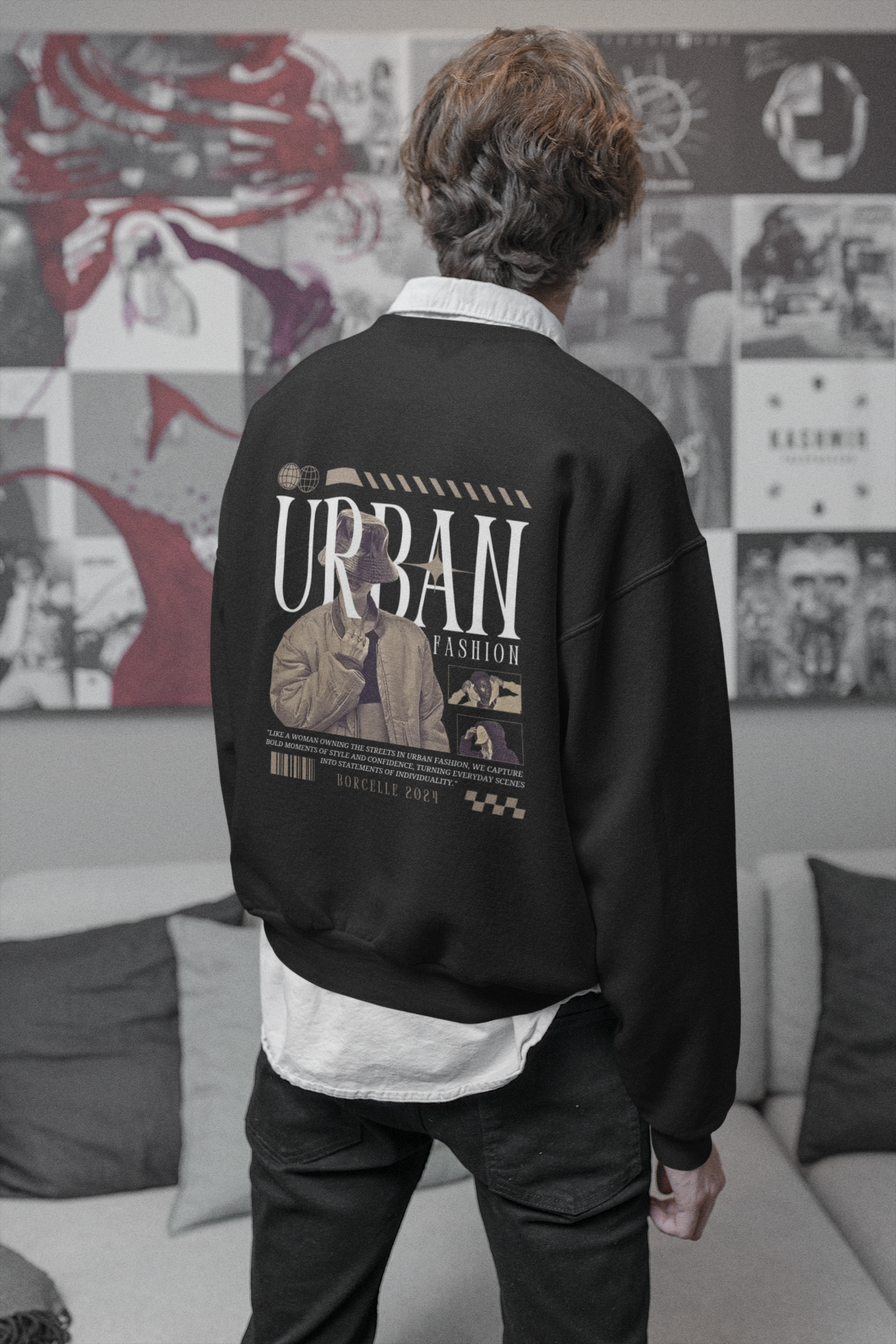 Person wearing a black sweatshirt with 'Urban Fashion' text and graphics, standing in a room with a collage wall.