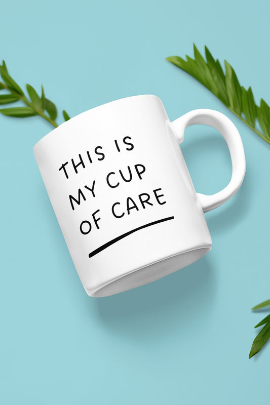 A white ceramic mug with the text 'THIS IS MY CUP OF CARE' printed in black. The mug is displayed against a blue background with some green leaves partially visible.