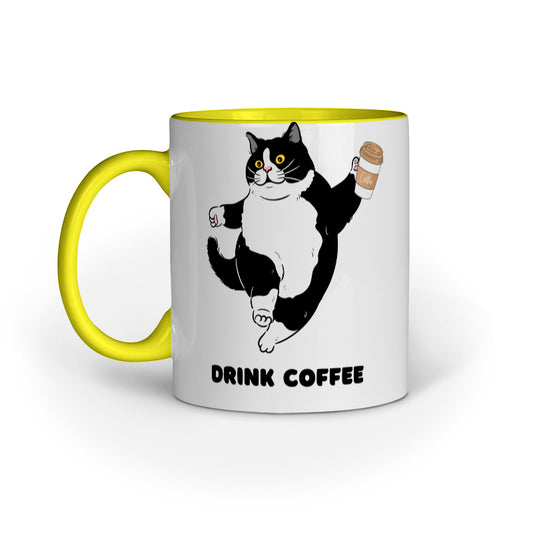 A white ceramic mug with a yellow handle and black and gray cat illustration, featuring the text 'DRINK COFFEE'.