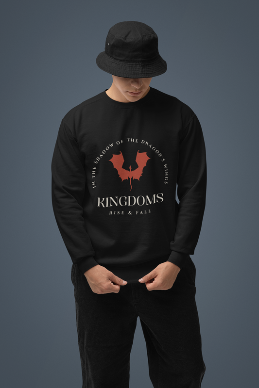 A person wearing a black long-sleeve sweatshirt with text and a logo on the front, paired with black pants and a black hat.