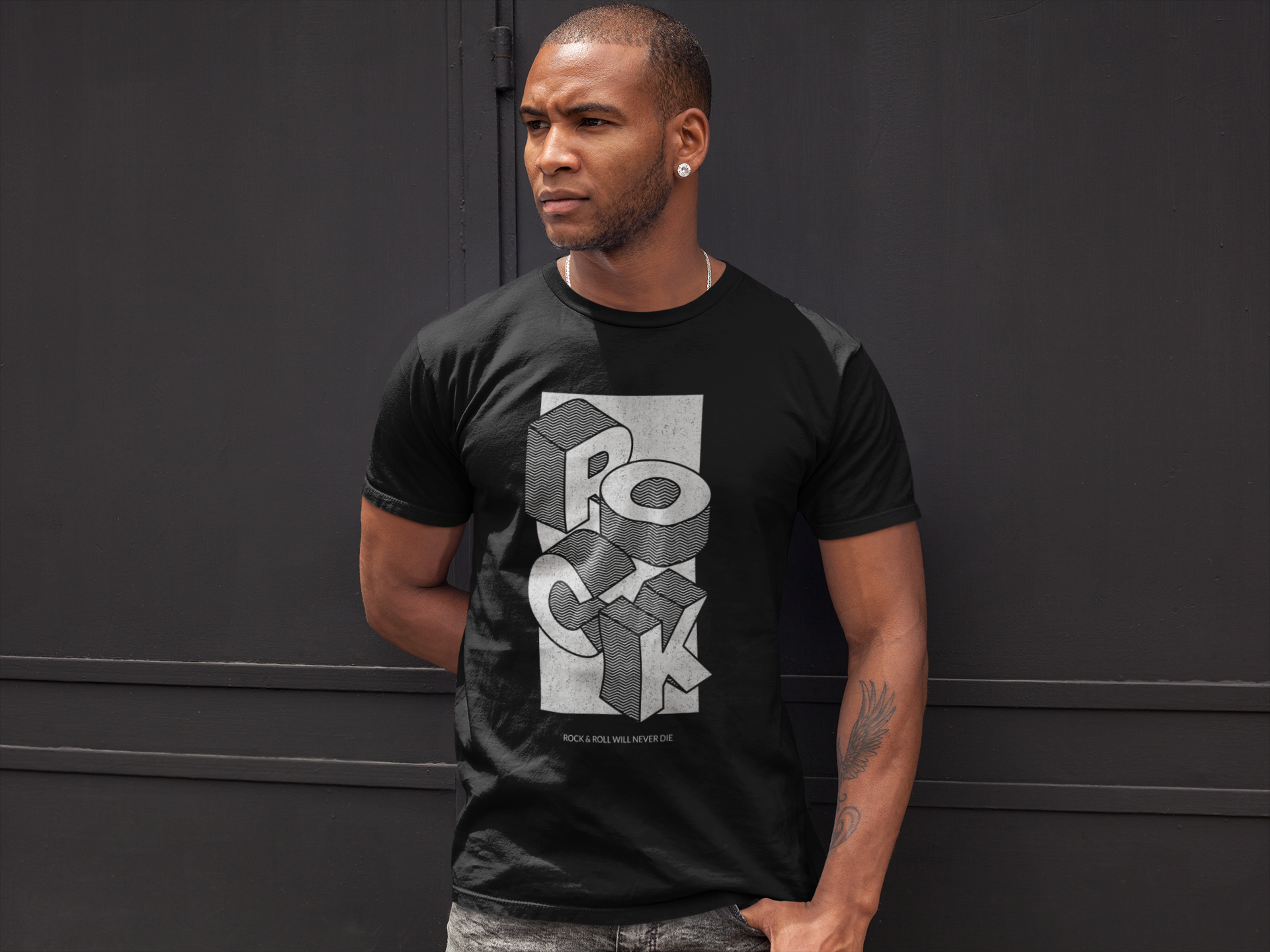 A man wearing a black crew neck t-shirt with the word 'ROCK' depicted in stylized letters on the front.