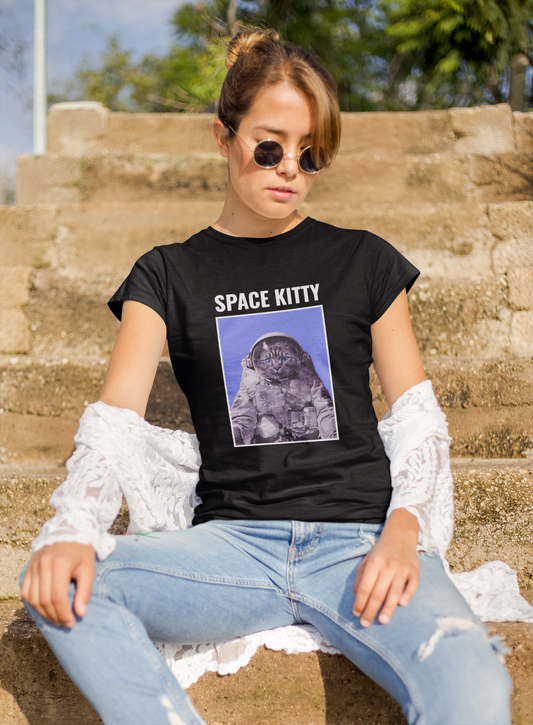 A woman sitting on outdoor steps wearing a black t-shirt with a cat image and the text 'SPACE KITTY', paired with blue jeans and white lace sleeves.
