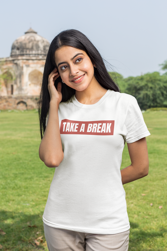 Woman wearing a white t-shirt with 'TAKE A BREAK' text in a park-like setting