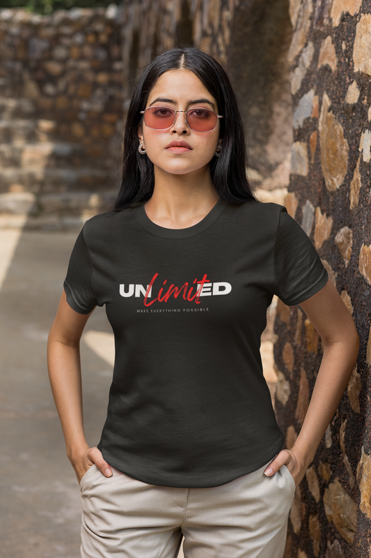Person wearing a black t-shirt with 'UNLIMITED' text standing against a stone wall.