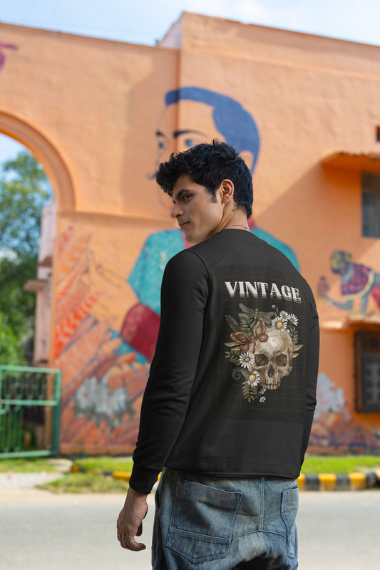 Person wearing a black 'Vintage' sweatshirt with a skull design, standing in front of a colorful mural.
