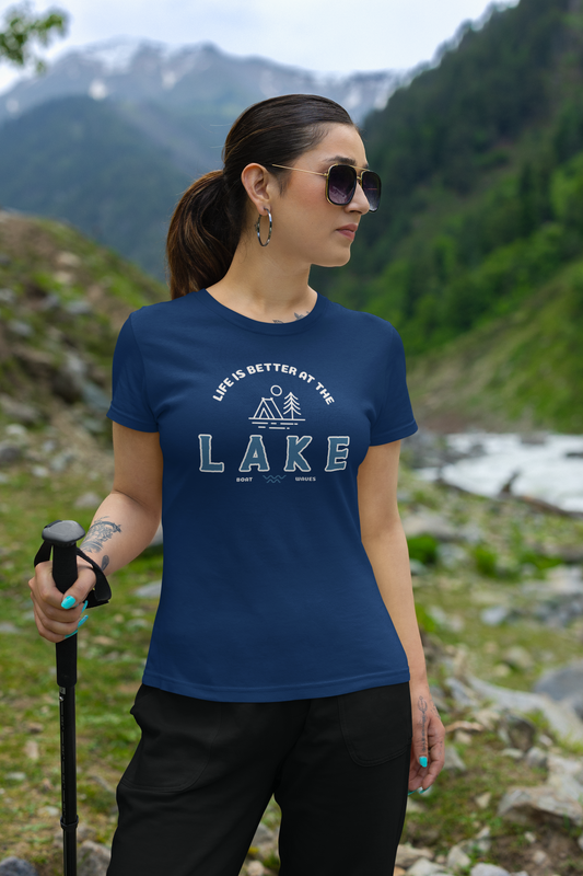 Woman hiking in a mountainous area wearing a blue t-shirt with a lake design.