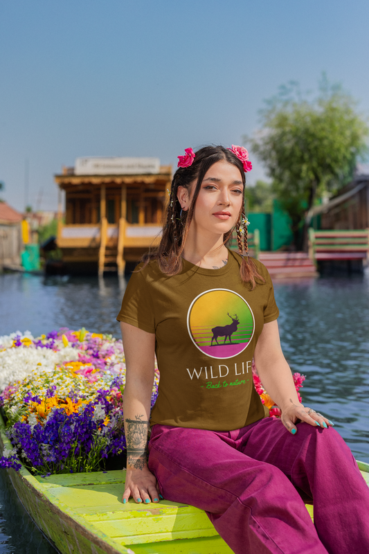 Woman sitting on a boat with a scenic background wearing a 'Wild Life' t-shirt.