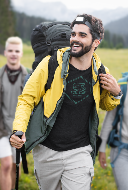 Man hiking in a yellow jacket with a backpack and hiking poles, surrounded by nature.