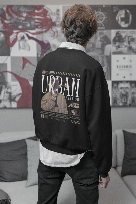 Person wearing a black sweatshirt with 'Urban Fashion' text and graphics, standing in a room with a collage wall.
